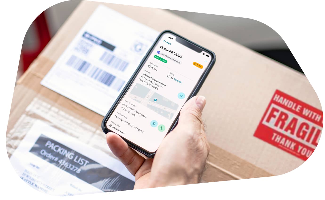 A hand holding a smartphone displaying order details from the carGO Health app.