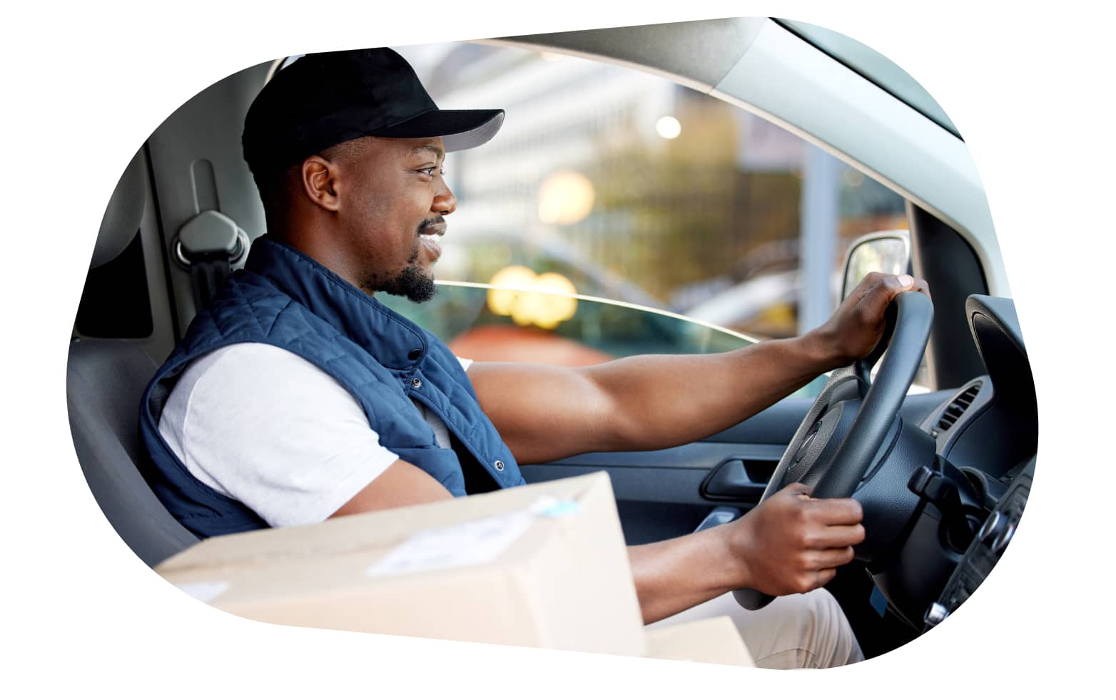 A carGO Health driver smiling while driving a vehicle, with packages visible in the front seat.